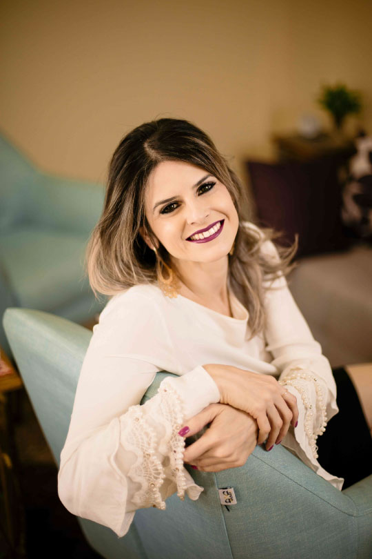 Imagem de Andressa Tripiana sentada no sofá